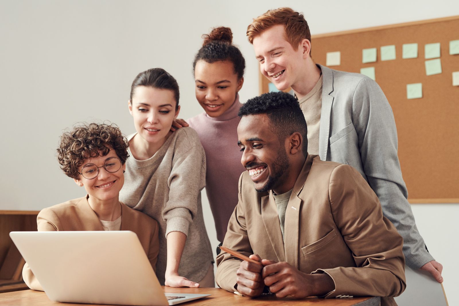 Colleagues collaborating around a laptop