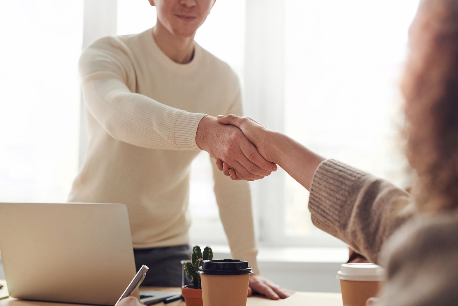 Colleagues welcoming a new team member with a handshake